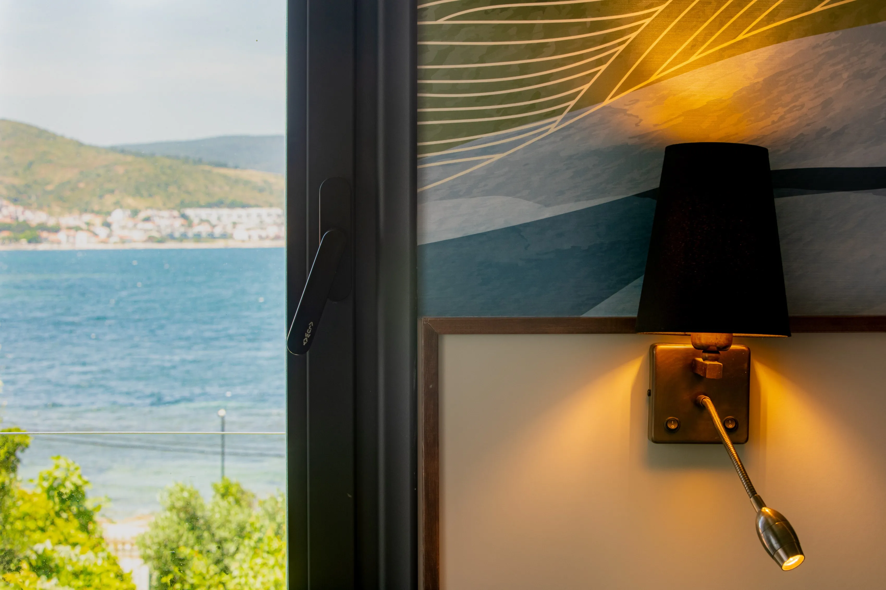 Der Golf von Izmir aus einem Hotelzimmerfenster: die Bucht im Morgenlicht, die Hügel des gegenüberliegenden Ufers und Grün am Fenster